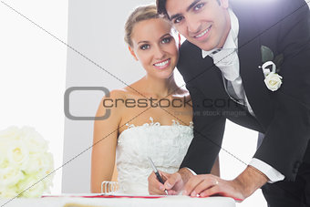 Happy bridegroom signing wedding contract