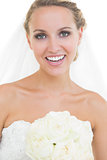 Cheerful young bride posing holding a bouquet