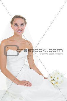 Cheerful young bride sitting on floor