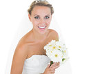 Side view of cheerful young bride holding a bouquet