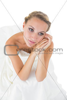 Pretty thoughtful bride sitting on floor