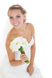Content young bride sitting on floor holding a bouquet