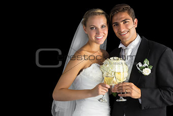 Happy young married couple posing holding champagne glasses