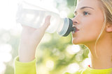 Fit blonde drinking from sports bottle