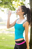 Active attractive brunette drinking from a water bottle