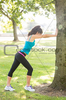 Active attractive brunette stretching her leg