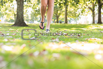 Close up of female feet wearing sandals walking on grass