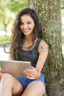 Casual attractive brunette sitting using tablet