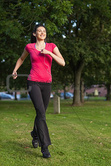 Happy woman running in a green park