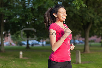 Motivated sporty woman running in a park