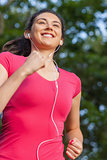 Smiling sporty woman jogging in a park