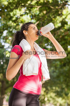 Cute sporty woman having a break and drinking water