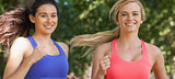 Two cute sporty women running in a park