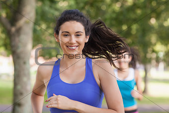 Lovely brunette woman running in a park