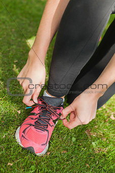 Young sporty woman tying her shoelaces