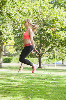 Side view of sporty woman skipping