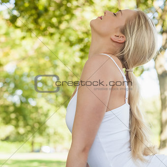 Profile view of blonde young woman doing yoga in a park