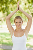 Lovely young woman doing yoga in a park