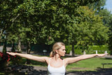 Young woman doing yoga spreading her arms
