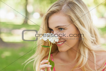 Content young woman smelling a white flower