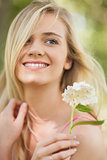 Happy blonde woman holding a white flower