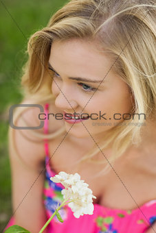 High angle view of content young woman holding a white flower