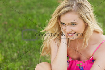 Content cute woman sitting on a lawn