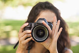Front view of young brunette woman taking a picture