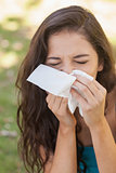 Sick brunette woman using a handkerchief