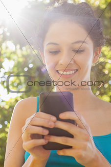 Content young woman dialing with her smartphone