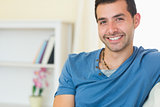 Casual smiling man relaxing on couch looking at camera