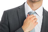 Close up of businessman adjusting tie