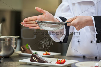 Female chef finishing a dessert plate