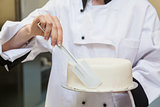 Chef finishing a cake with icing
