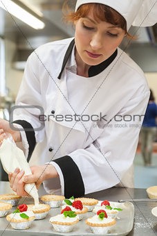 Pretty concentrated head chef preparing dessert