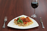 Front view of spaghetti and meatballs with red wine
