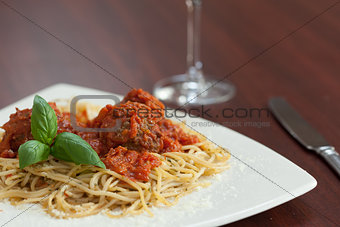 Close up of spaghetti and meatballs with red wine