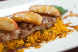 Close up of couscous with meat garnished with apple