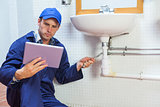 Serious plumber consulting tablet