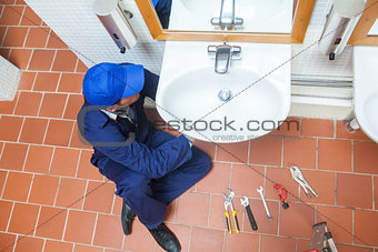 Plumber with cap repairing sink
