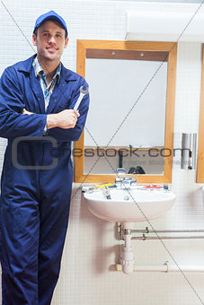 Happy plumber posing with wrench