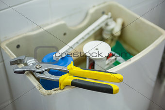 Close up of pliers lying on toilet