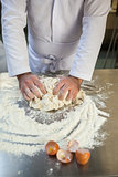 Close up of baker kneading dough