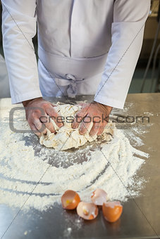 Close up of baker kneading dough