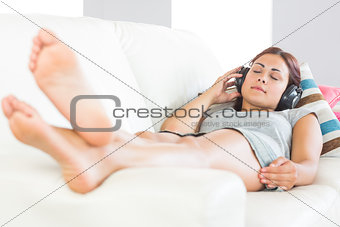 Young brunette woman listening to music with closed eyes