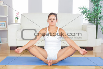 Peaceful brunette relaxing on exercise mat