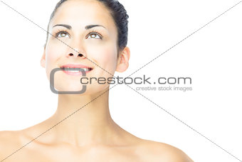 Front view of cheerful brunette woman looking upwards