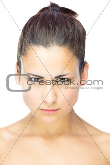 Front view of focused young woman gazing at camera