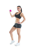 Fit slender woman training her arm using a pink dumbbell