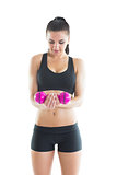 Front view of beautiful sporty woman holding a pink dumbbell